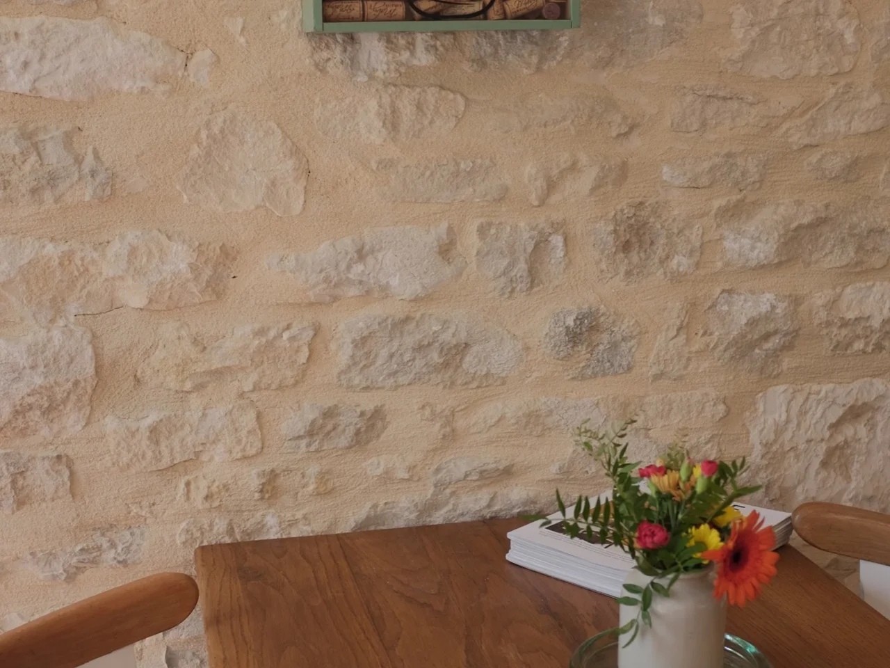 Cork-filled Bonheur frame above the dining table on a limestone wall