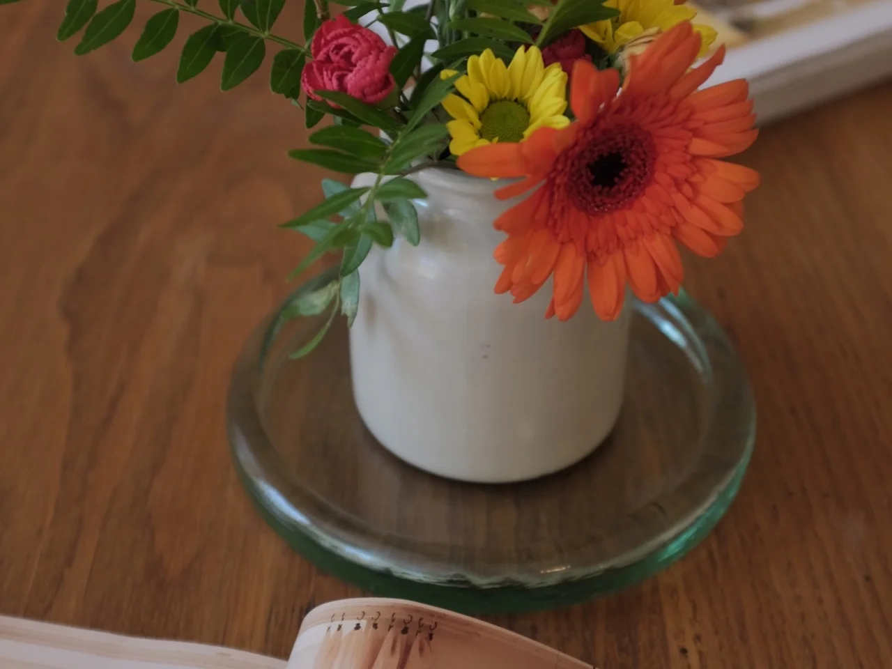 Gerbera and rose posy on the dining table beside an open magazine