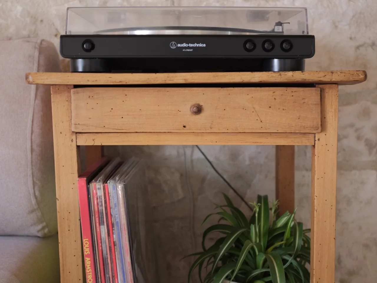 Audio-Technica turntable and vinyl records on a rustic side table