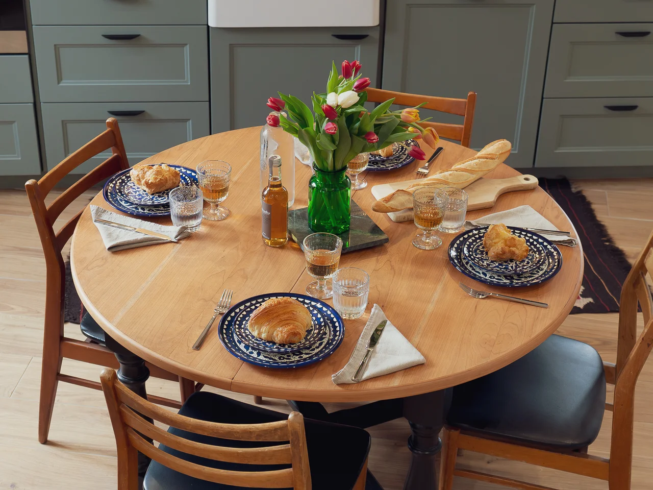 Round dining table with pastries and tulips