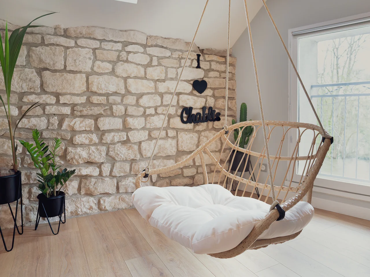 Wicker hanging chair by stone wall